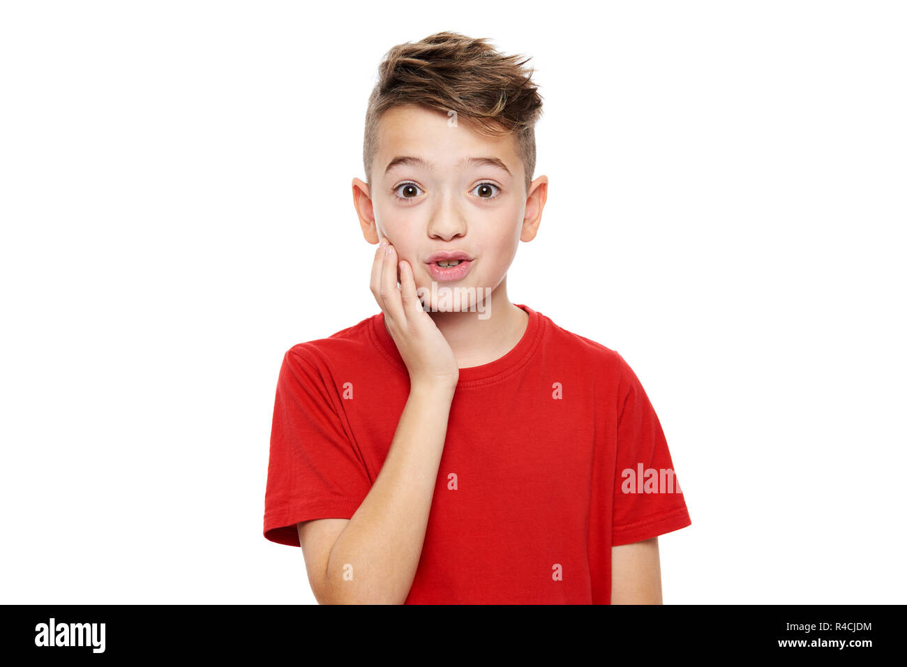 Adorable young boy in shock, isolated over white background. Shocked child looking at camera in disbelief. Shock, amazement, surprise concept. Stock Photo