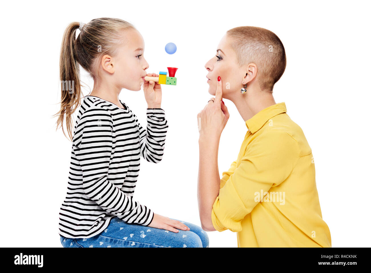 Cute young girl with speech therapist making special exercises at speech therapy office. Child speech therapy concept on white background. Speech impe Stock Photo