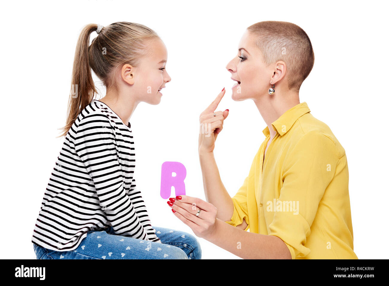 Cute young girl with speech therapist practicing correct pronunciation. Child speech therapy concept on white background. Speech impediment corrective Stock Photo