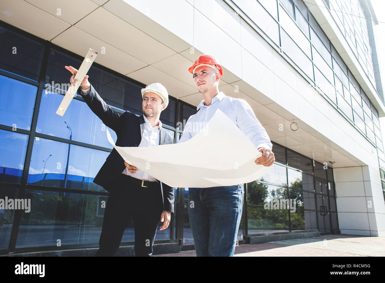 View of an Engineer and worker checking plan on construction site Stock Photo
