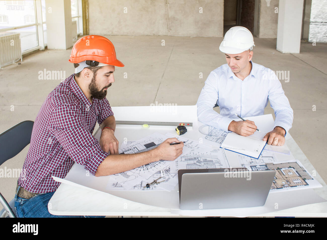 Male Engineers Architects Working At The Desk In Helmets