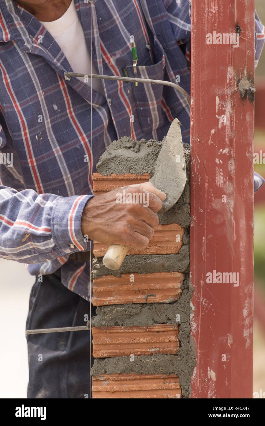 Bricklayer working in construction site of brick wall Stock Photo - Alamy