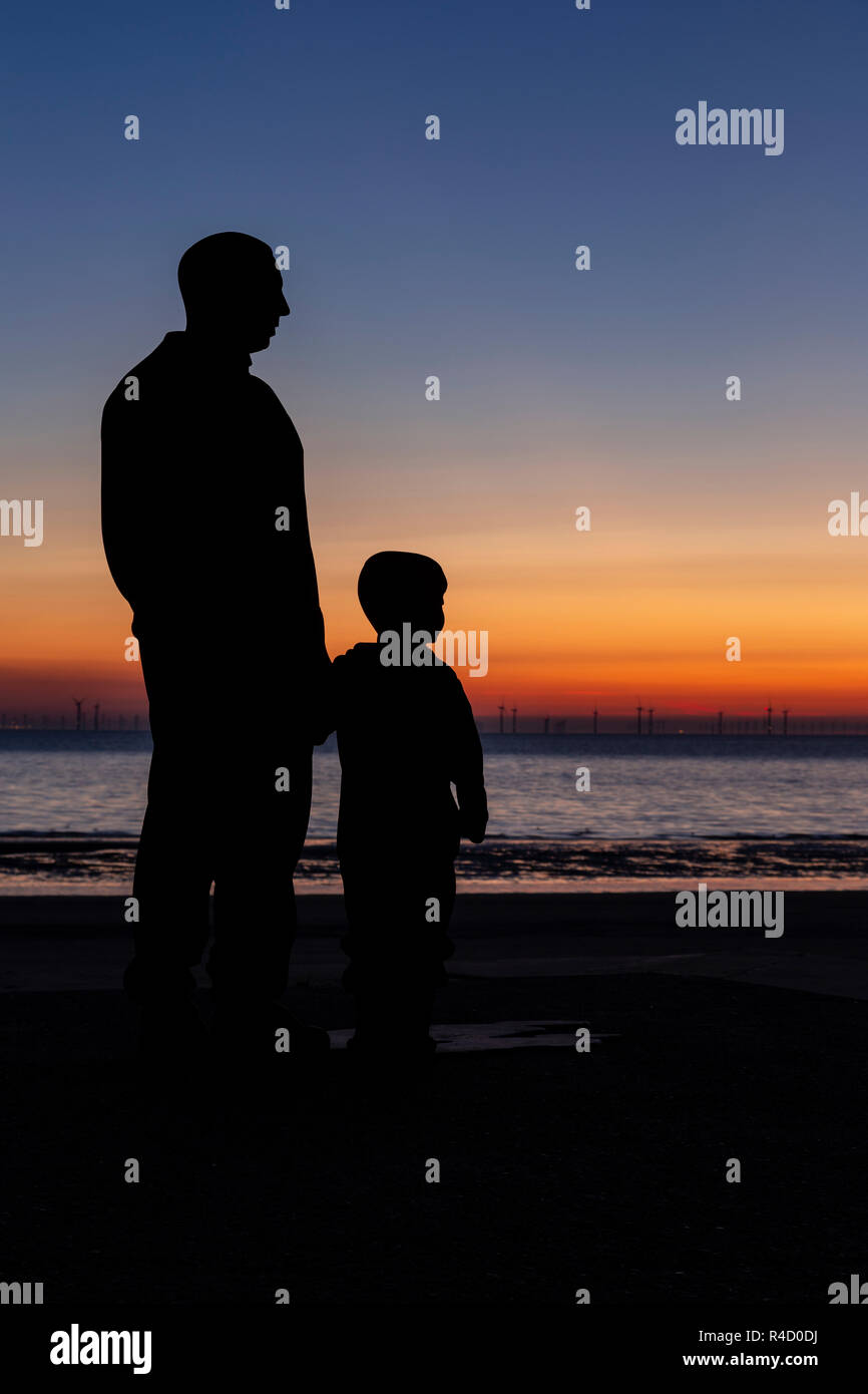 Sculptures of families on the seafront at Colwyn Bay at dawn, North Wales Stock Photo