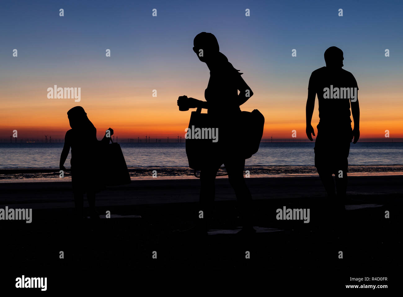 Sculptures of families on the seafront at Colwyn Bay at dawn, North Wales Stock Photo