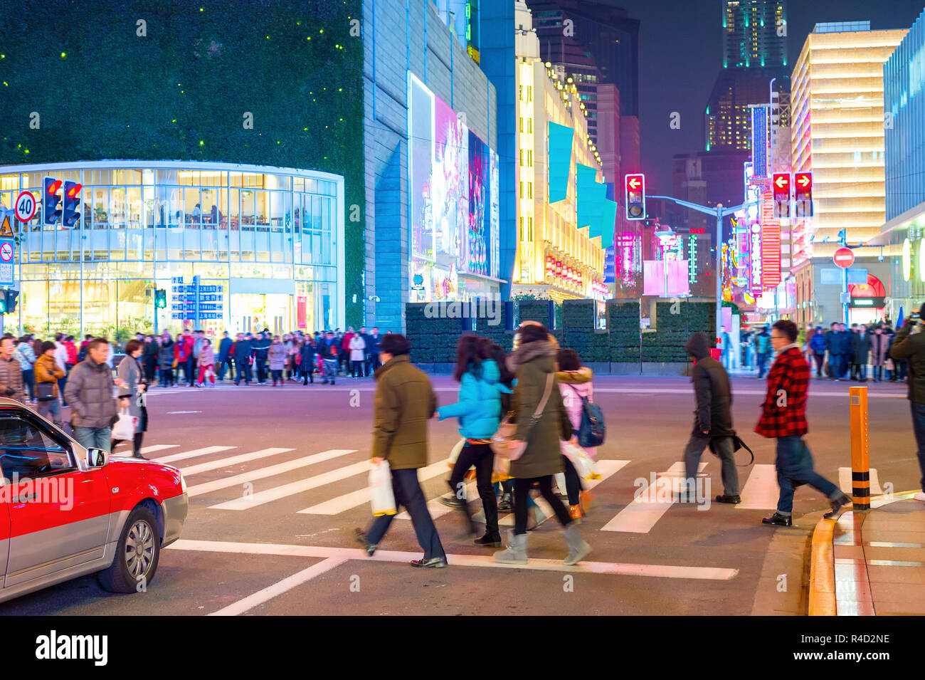 Illuminated with neon night shopping street of Shanghai downtown, crowds of people walking at crossroads, China Stock Photo