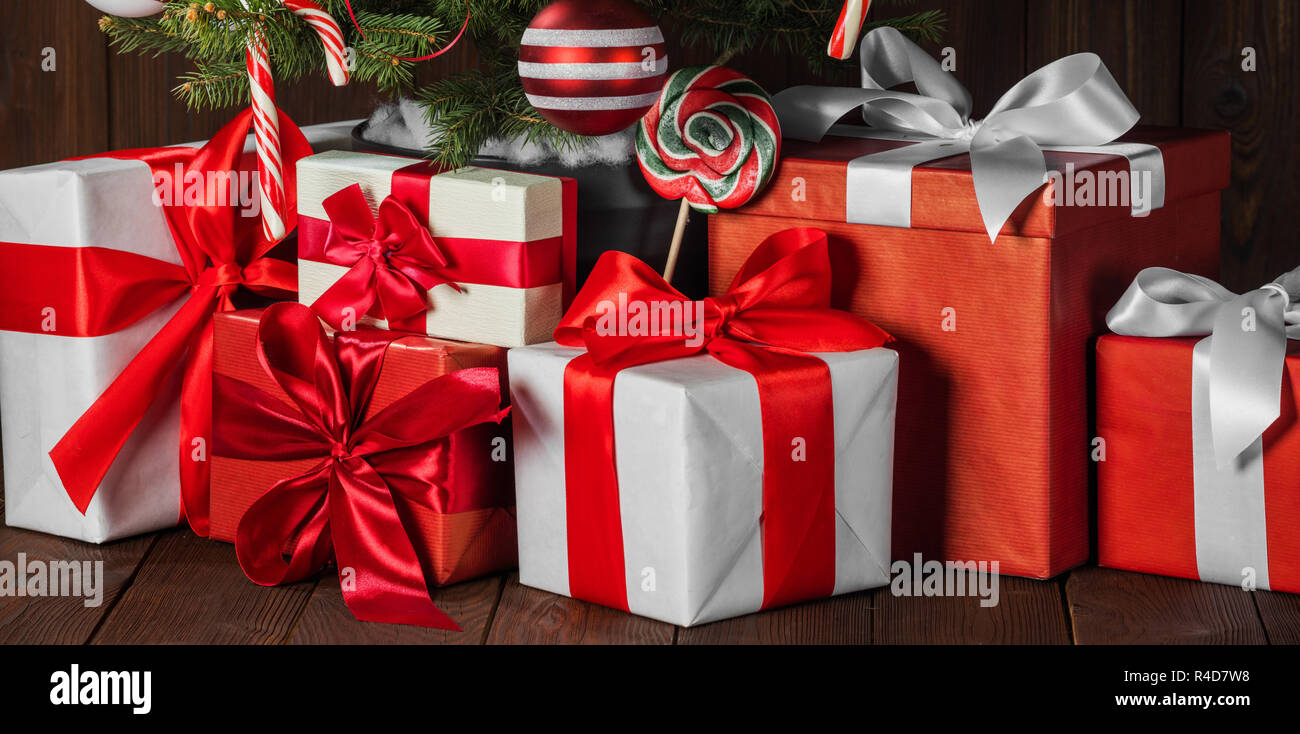 Decorated Christmas gifts under tree with candy canes and striped baubles Stock Photo