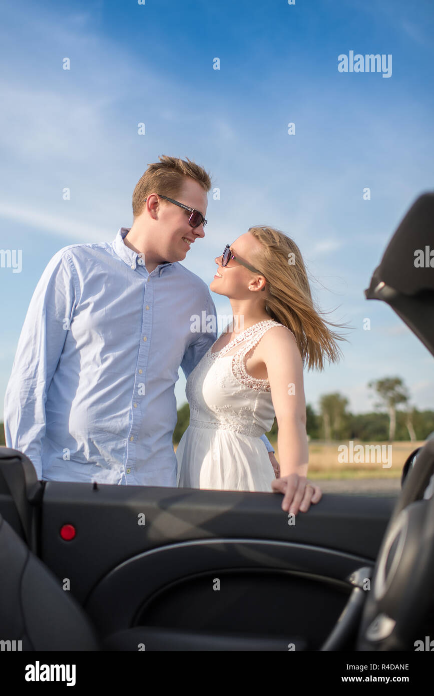 loving couple is on the convertible and looks in love with the eyes Stock Photo