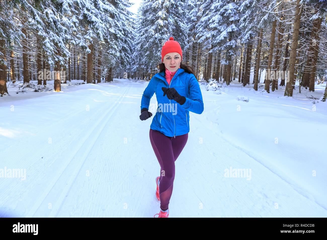 A young woman jogging in the wintry forest Stock Photo - Alamy