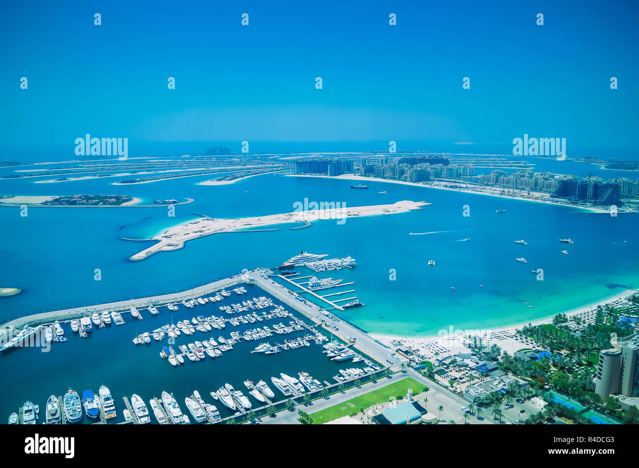 Aerial view of Palm Jumeirah Island with luxury yachts in the front. Development of Dubai. Stock Photo