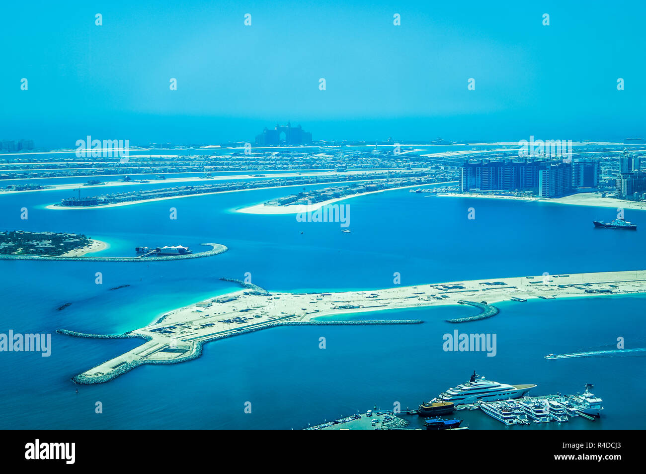 Aerial view of Palm Jumeirah Island with luxury yachts in the front. Development of Dubai. Stock Photo