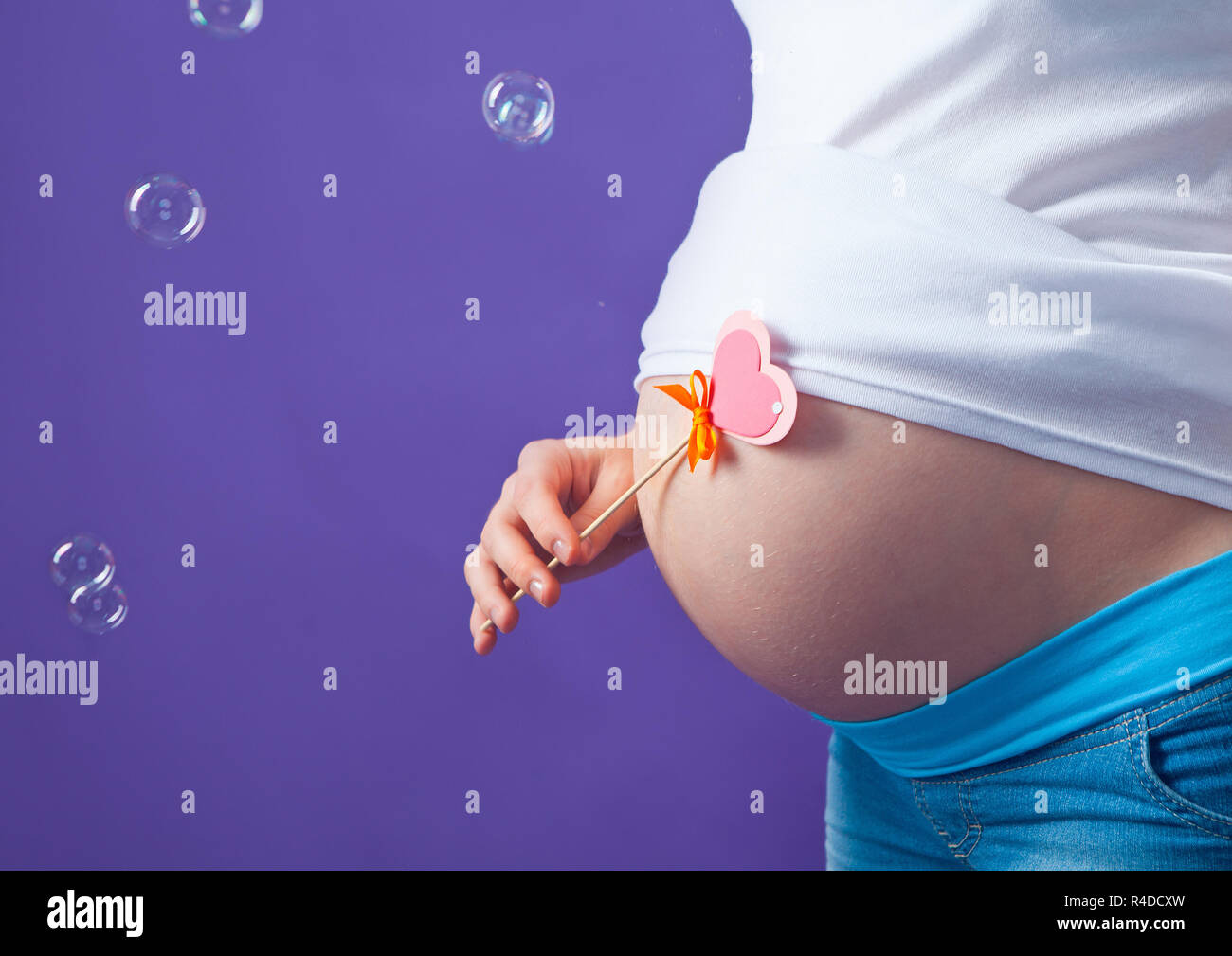caucasian pregnant woman stress anxious with butterfly in the stomach isolated studio on gray