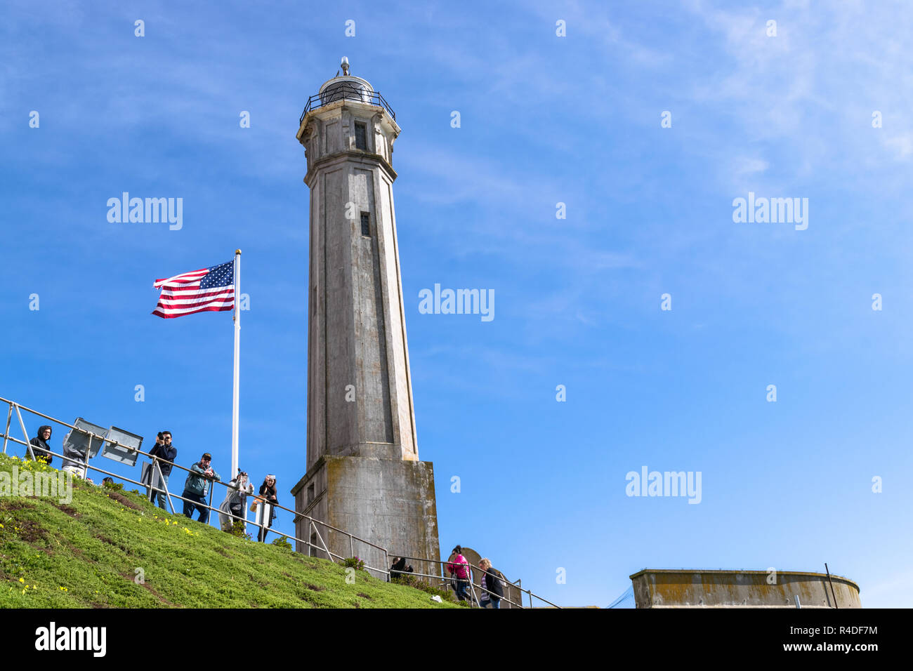 SAN FRANCISCO, USA - FEBRUARY 25, 2017: Lighthouse on Alcatraz Island against the blue sky in San Francisco, California and with tourists taking photos. Stock Photo