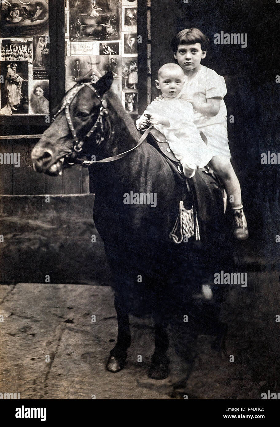 Two brothers on a pony in New York outside a movie theatre, circa 1922. Stock Photo