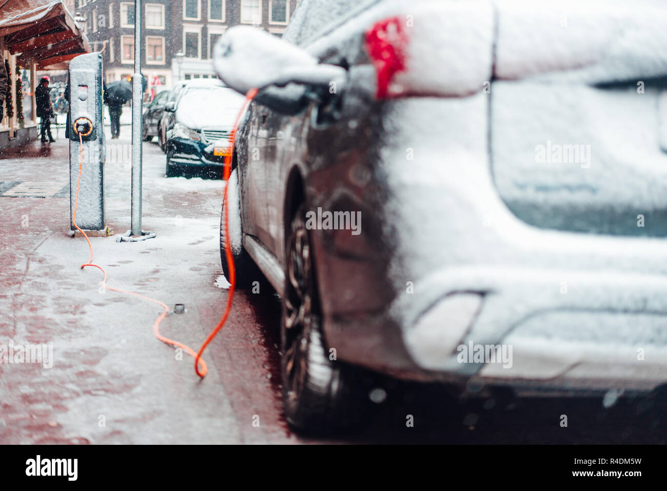 Electric car plug charging in the winter Stock Photo Alamy