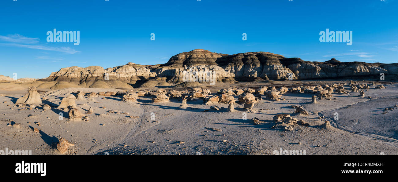 Panorama of the 'Cracked Eggs' rock field and rock formations in late afternoon sun in the Bisti Badlands in New Mexico Stock Photo