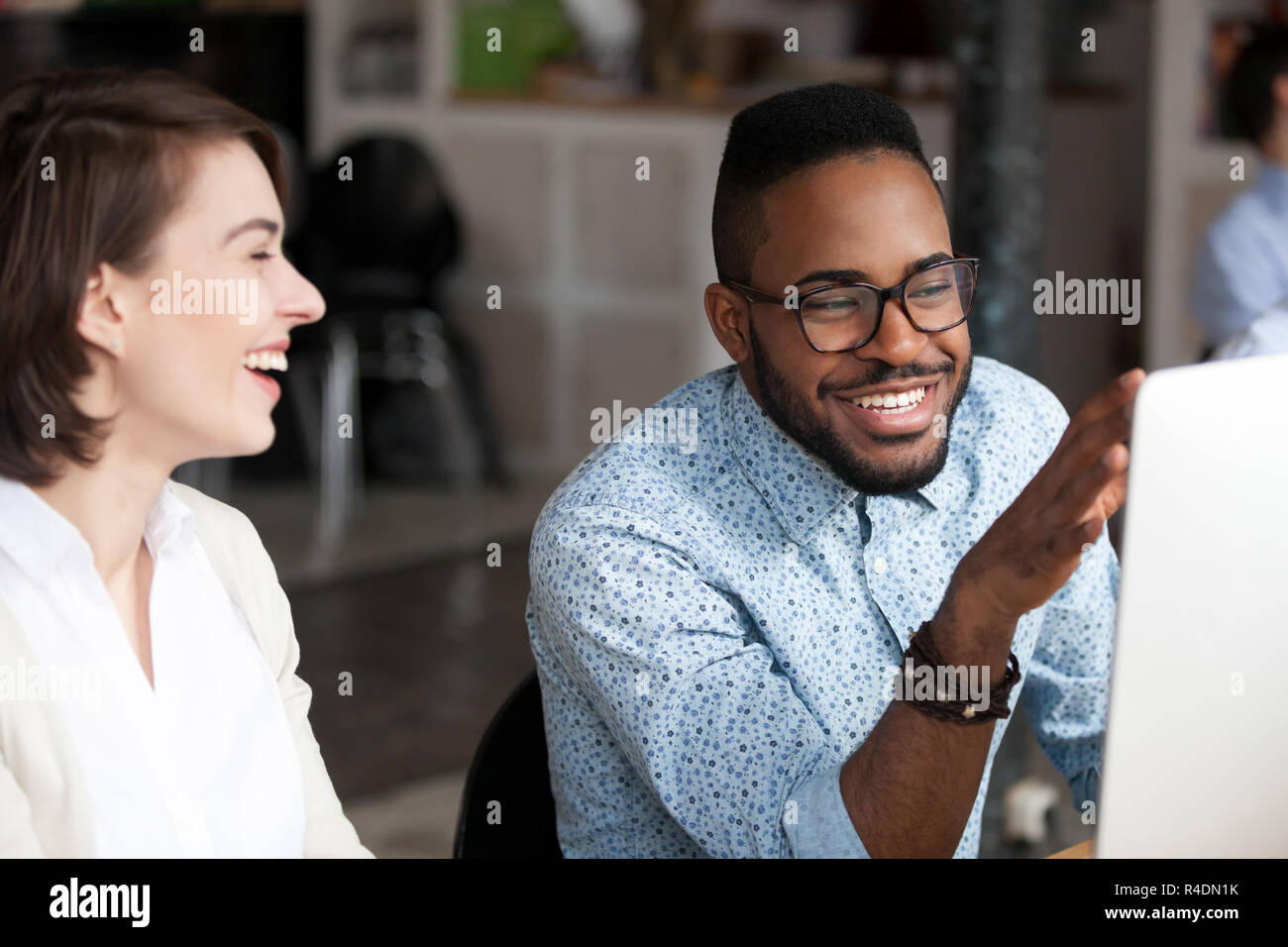 Smiling African American man talking with female colleague Stock Photo