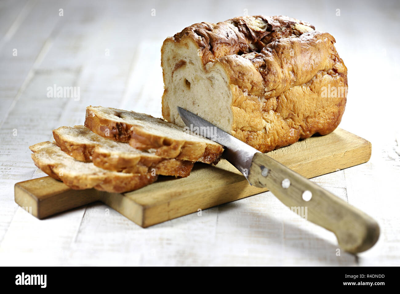 Frisian Suikerbrood (sugar bread) with knife on wooden plate Stock Photo