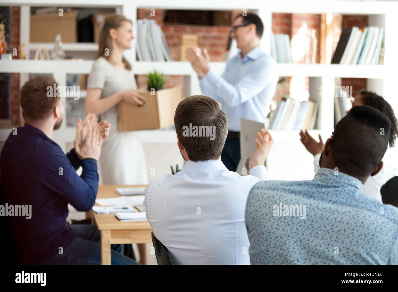 Team leader with colleagues applauding to just hired employee Stock Photo