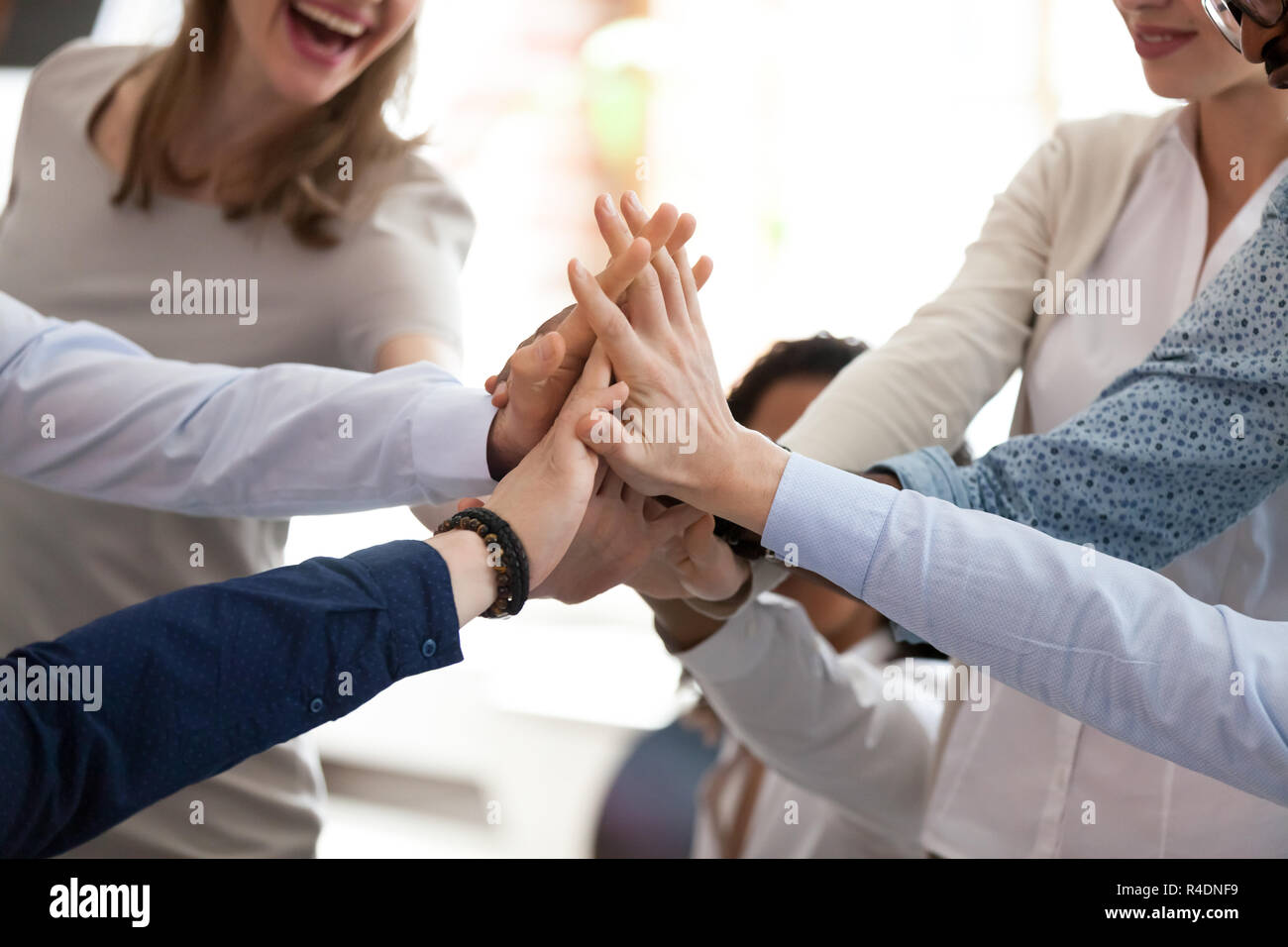 Excited multiracial team giving high five at briefing close up Stock ...