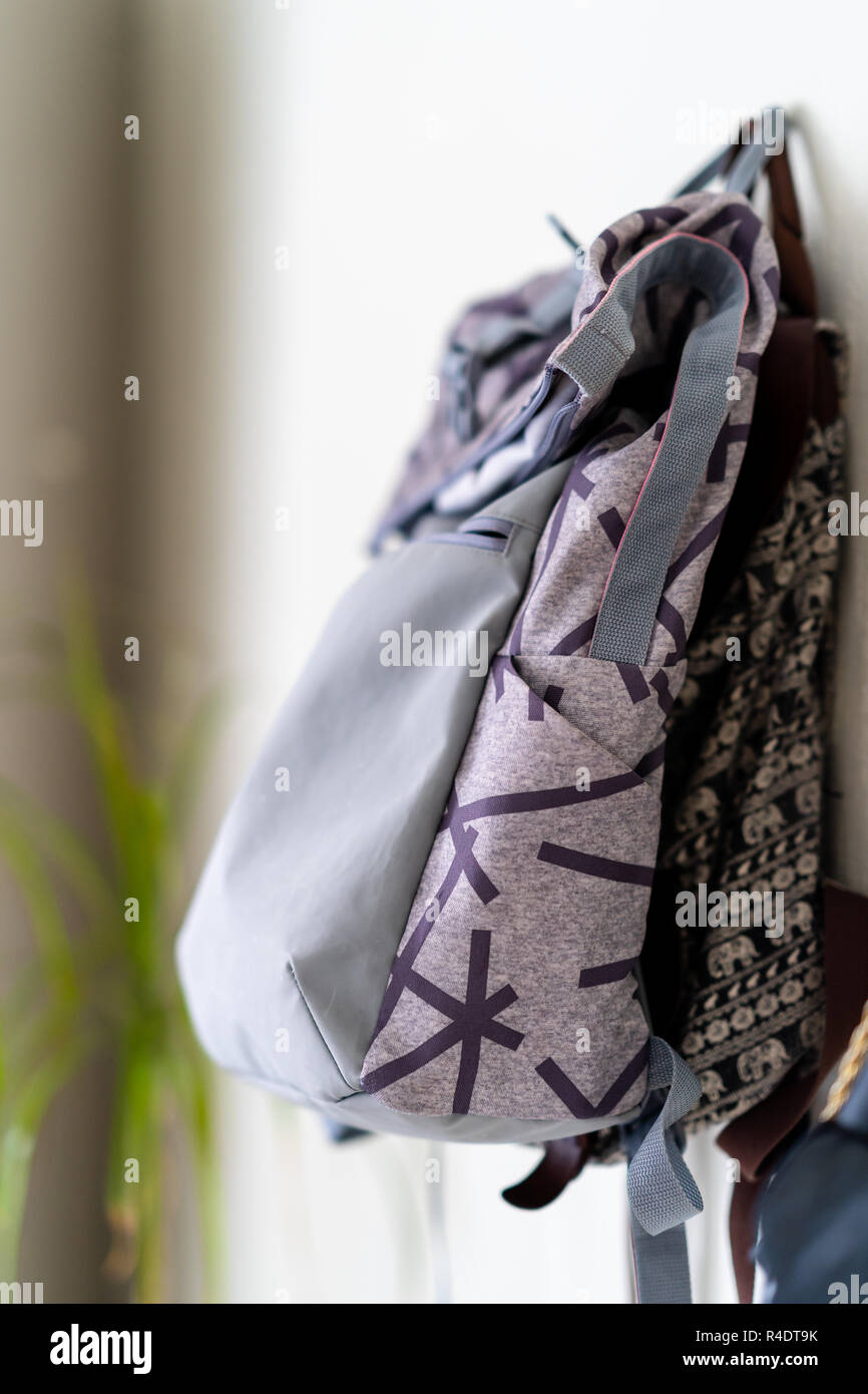 Purple School Backpack Hanging on the Wall - Isolated Object with White Background Stock Photo