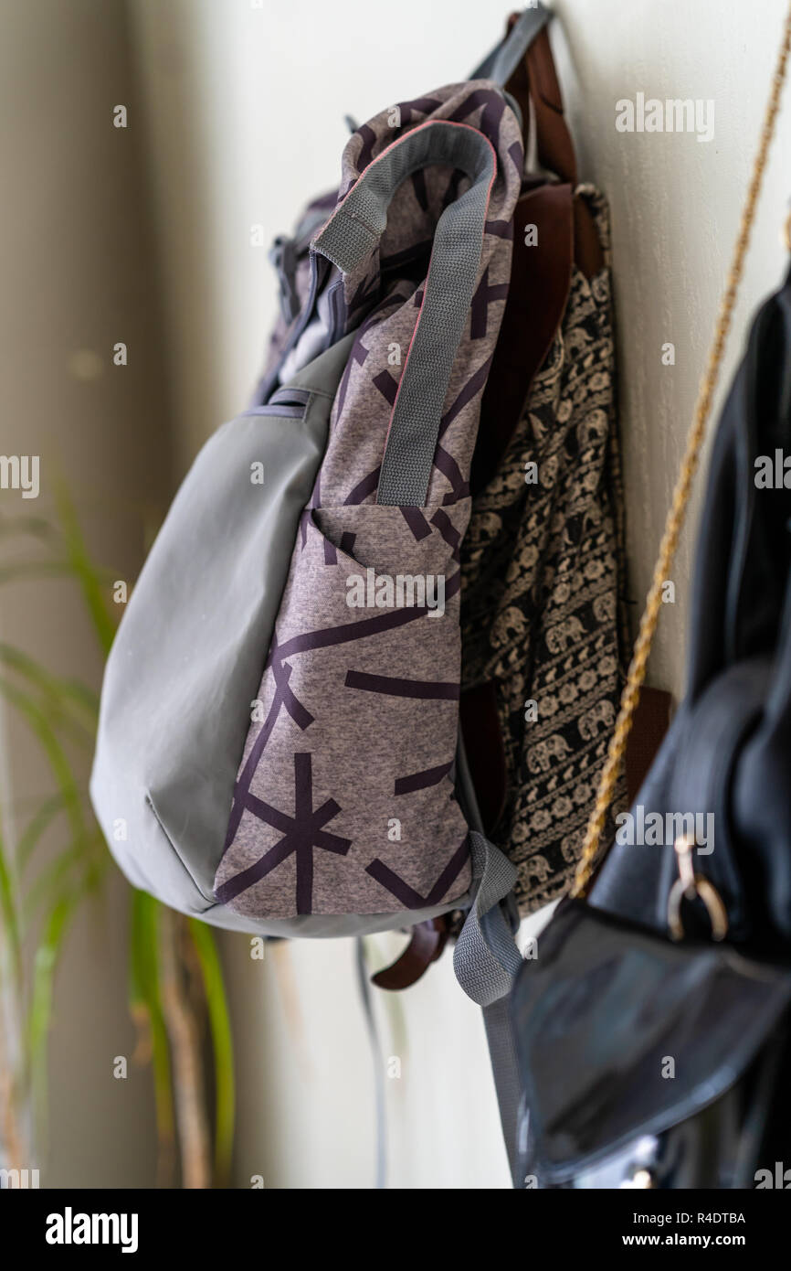 Purple School Backpack Hanging on the Wall - Isolated Object with White Background Stock Photo