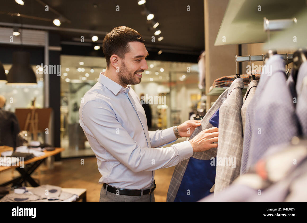 happy young man choosing clothes in clothing store Stock Photo - Alamy