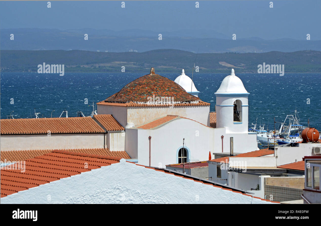 Sardinia, Italy, Sant'Antioco island, white church on the summit of the Calasetta city. The hilly coast and the sea of Sardinia in the background Stock Photo