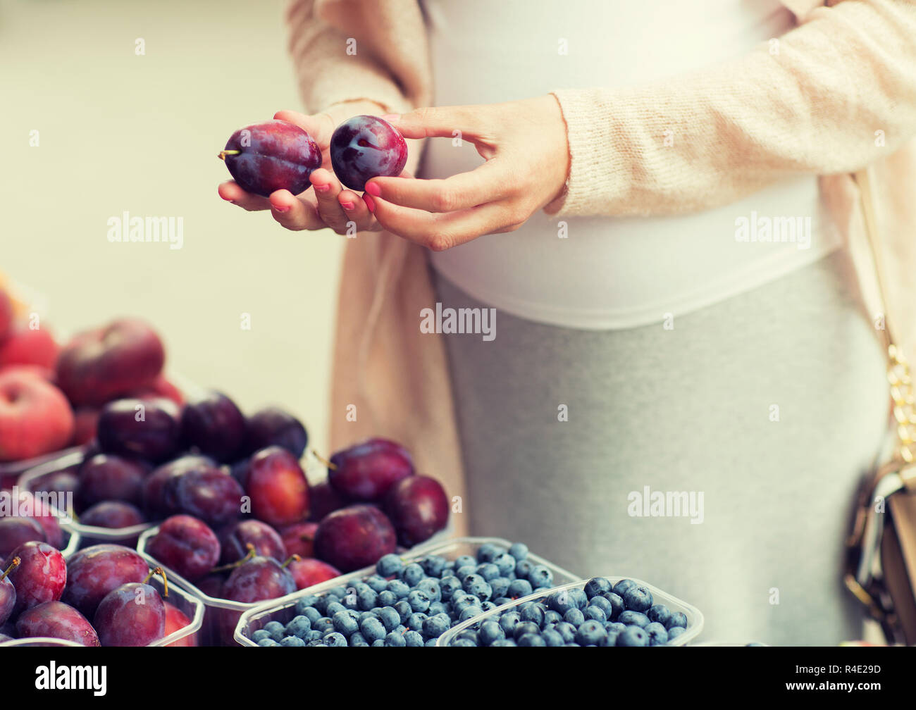 pregnant woman choosing plums at street market Stock Photo Alamy
