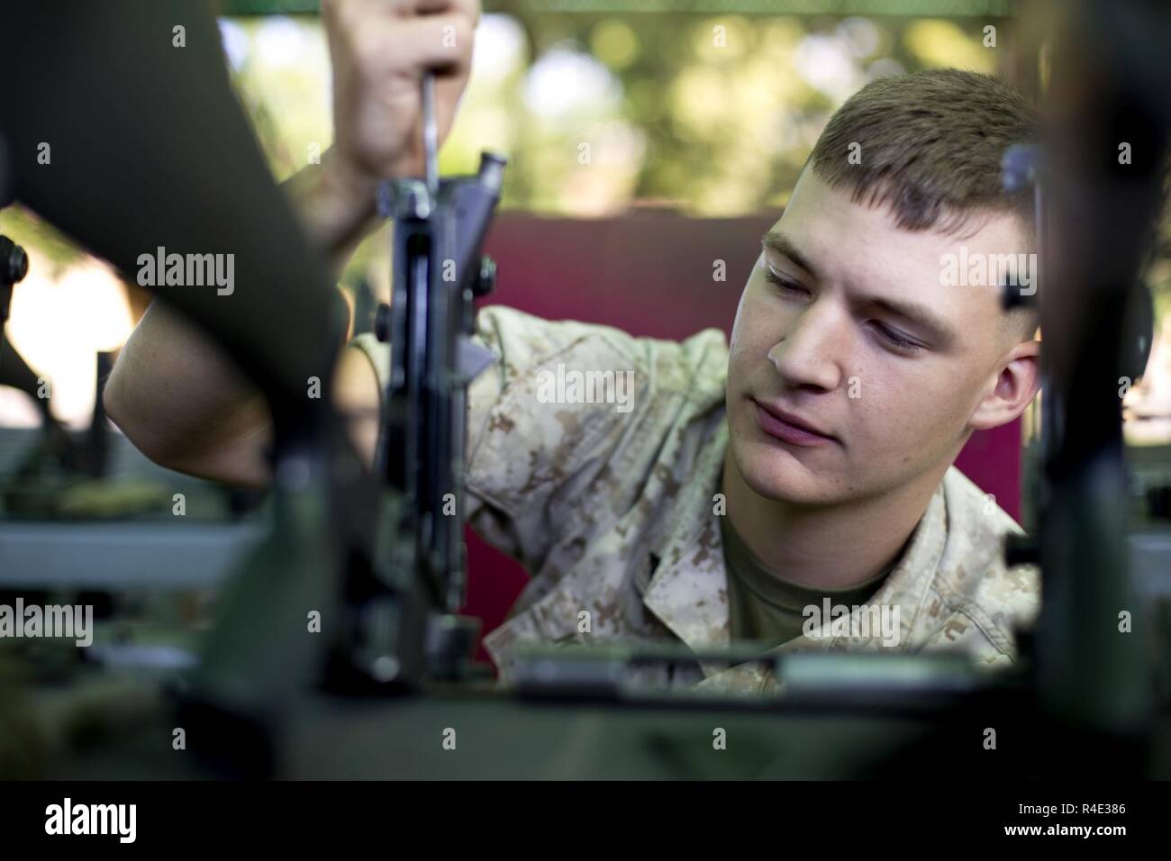 U.S. Marine Corps Lance Cpl. Kelly R. Keating, a small arms technician with the Armory, Service Company, Headquarters and Service Battalion, inspects a M16A4 rifle at Marine Corps Recruit Depot San Diego, Calif., Oct. 25, 2016. Keating ensured that the upper receiver of each rifle was returned in a serviceable condition. Stock Photo