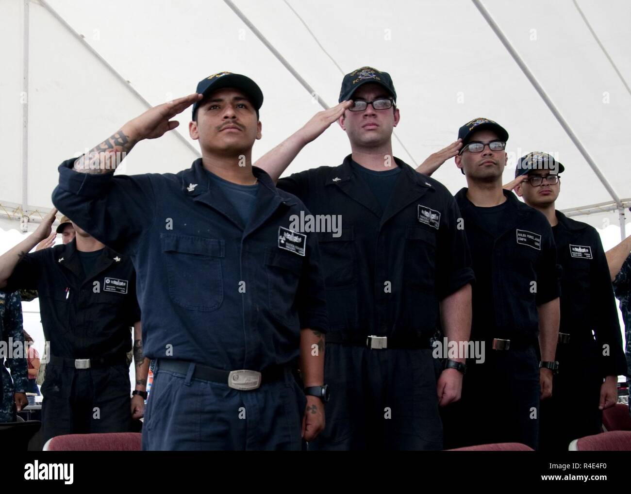 MANAMA, Bahrain (May 1, 2017) Sailors assigned to the Cyclone-class coastal patrol ship (PC) USS Whirlwind (PC 11) salute the ensign during the national anthem during the ship's change of command ceremony at Naval Support Activity Bahrain. The primary mission of the PCs is maritime security operations, and Whirlwind is one of 10 PCs forward deployed to Manama, Bahrain. Stock Photo