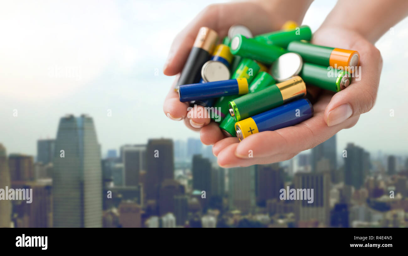 close up of hands holding alkaline batteries heap Stock Photo