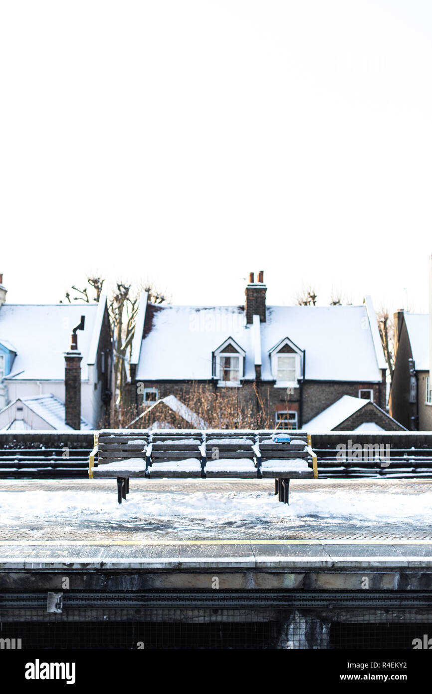 Snow covered bench on a train platform, Turnham Green, London, UK Stock Photo