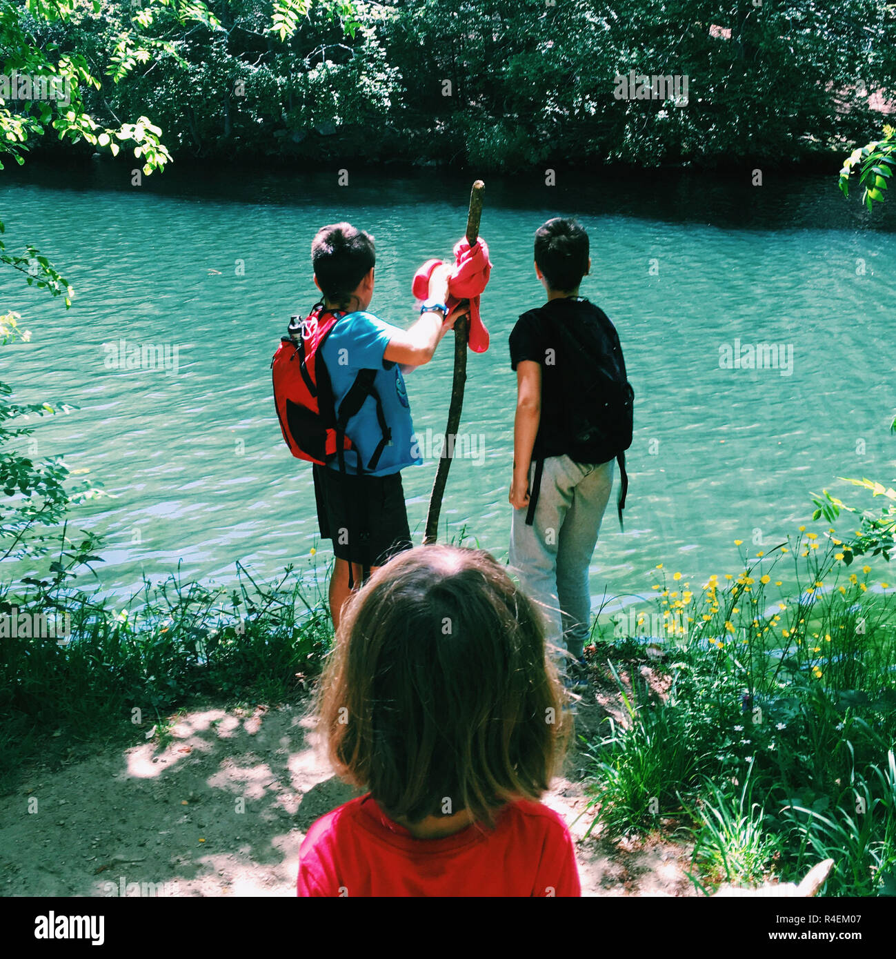 Three children hiking by a river in the summer, Spain Stock Photo