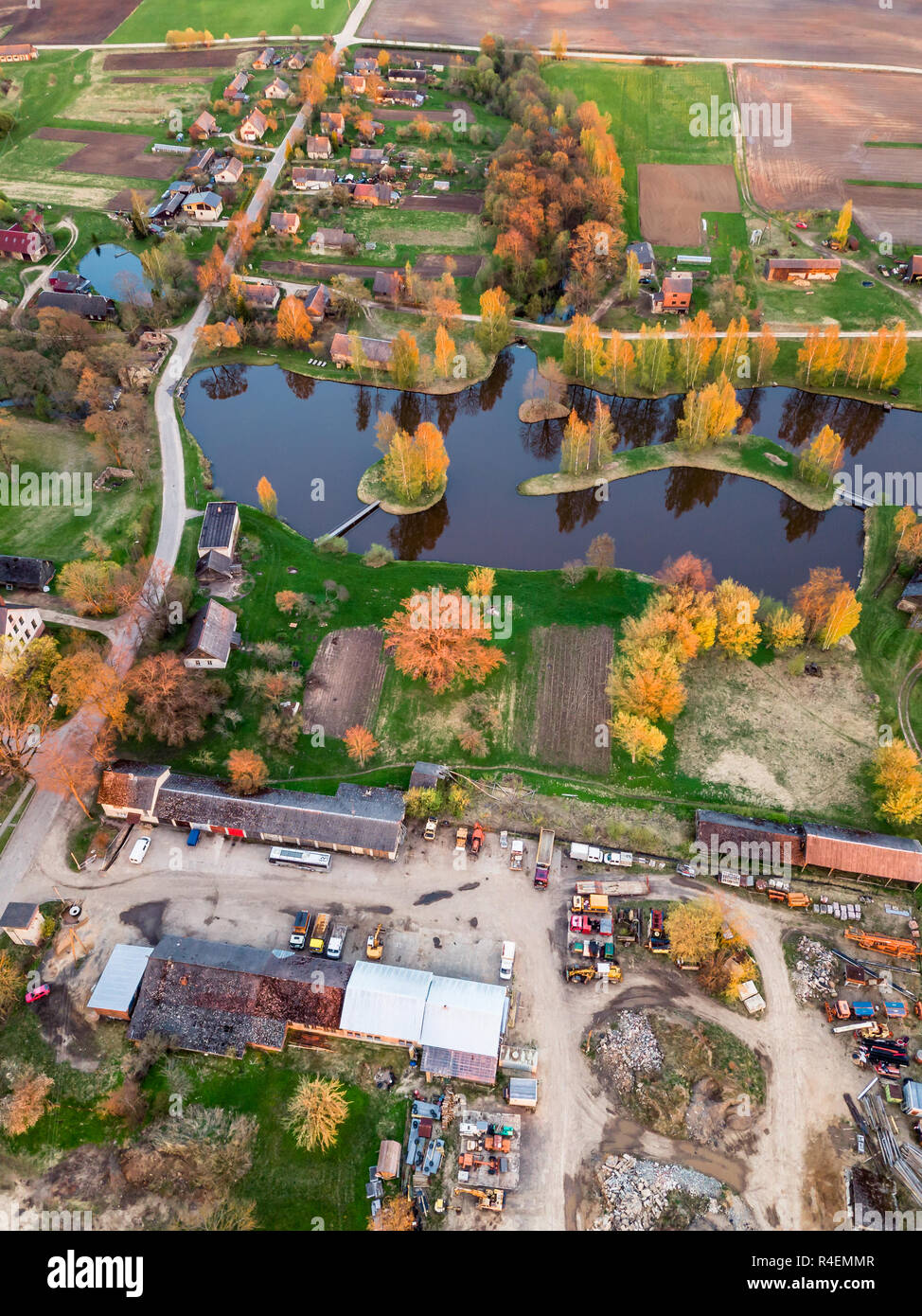 Aerial Drone Photograph of a  Village Surrounded with  Meadows  in Beautiful Spring Colours in Evening with Sunset Over it Stock Photo