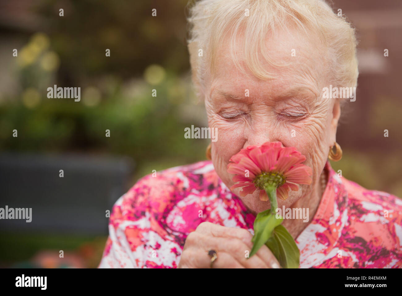 Senior Woman Smelling Flower, Eyes Closed Stock Photo