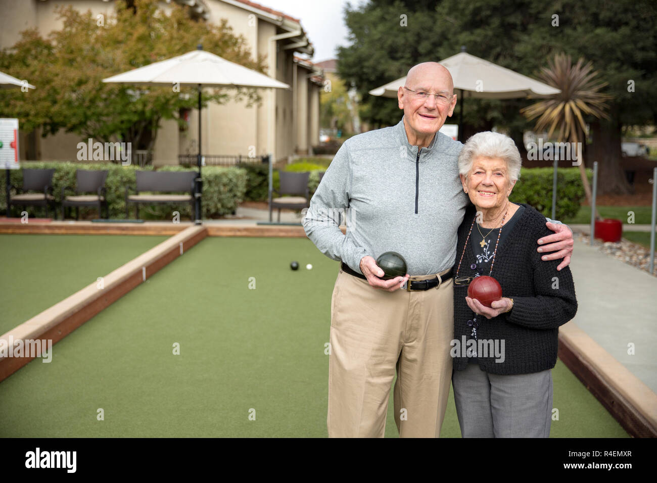 Senior Couple Standing on Bowling Green Holding Bowling Balls Stock Photo
