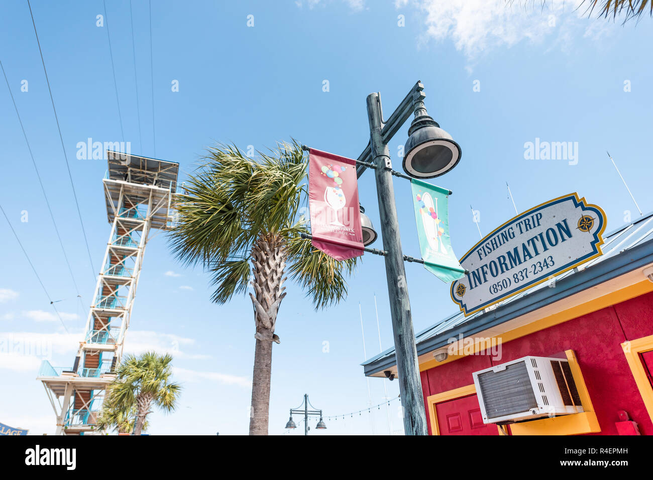 Destin, USA - April 24, 2018: City town Harborwalk village sign by Harbor Boardwalk during sunny day in Florida panhandle gulf of mexico, zip line tow Stock Photo