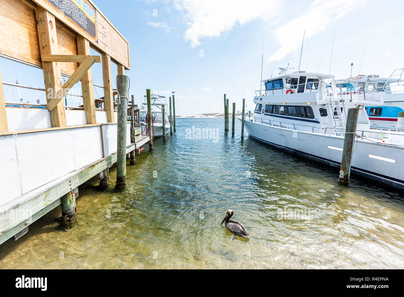 Destin, USA - April 24, 2018: City town Harborwalk village Harbor charter boat Boardwalk marina during sunny day in Florida panhandle gulf of mexico w Stock Photo