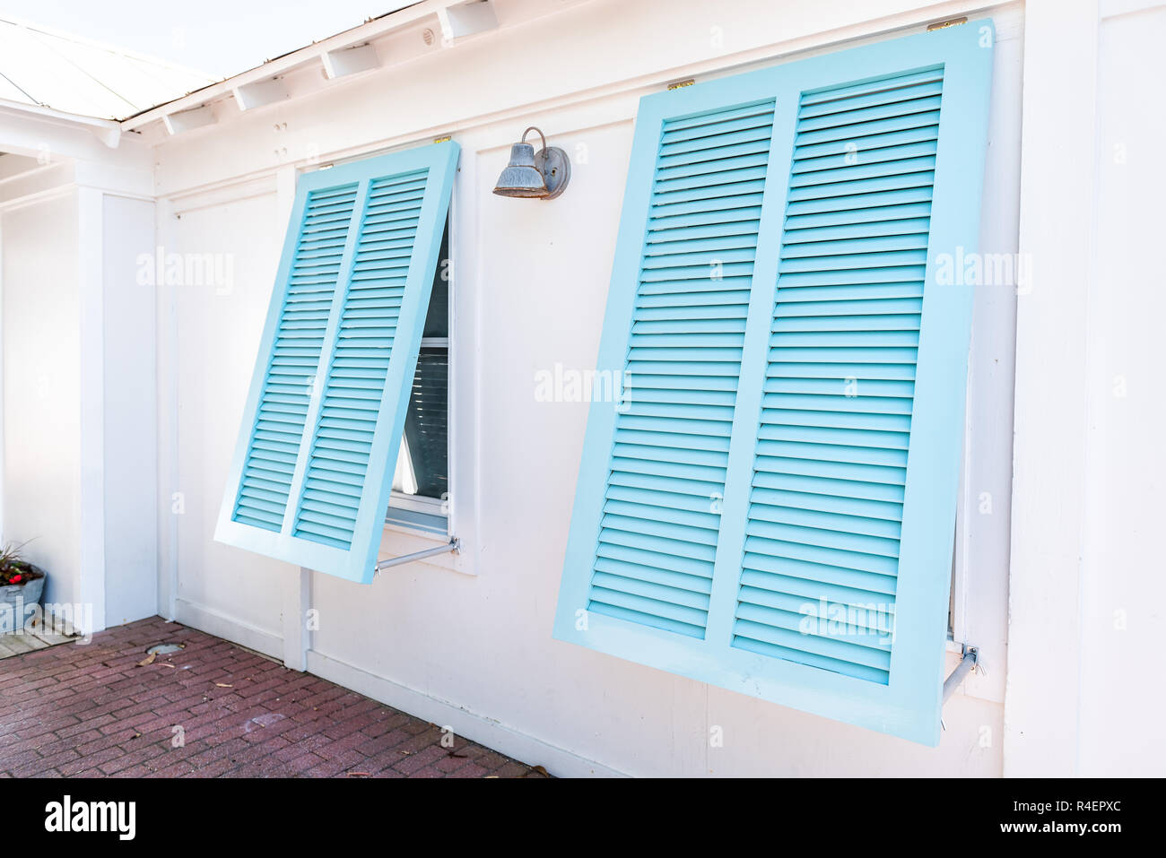 Pastel turquoise blue colorful hurricane window shutters closeup architecture open exterior of house in Florida beach home during sunny day, painted Stock Photo