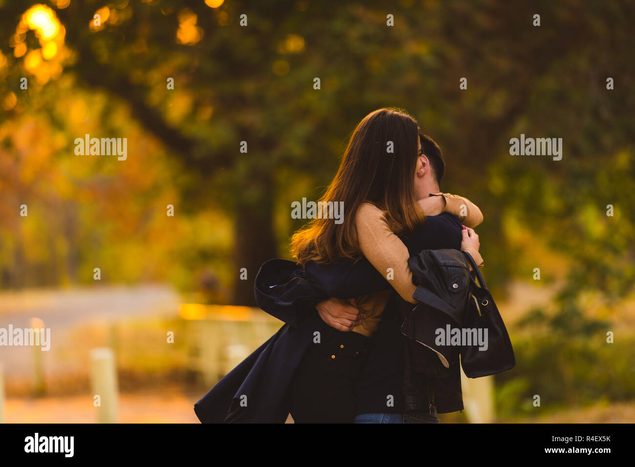 Young couple hugging and kissing at the park Stock Photo - Alamy