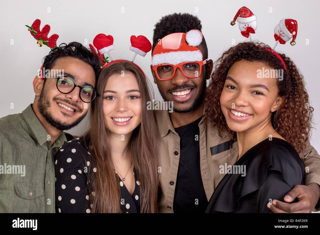 Four friends in funny New Year accessories. Stock Photo