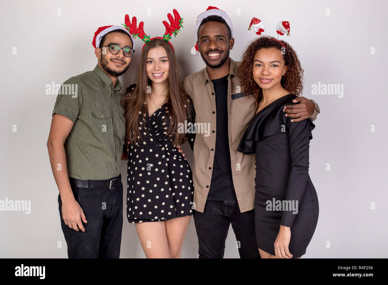 Group of friends in funny Christmas headbands and hats on a white  background Stock Photo - Alamy
