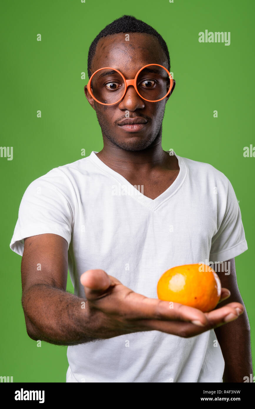 Studio shot of young African man against green background Stock Photo