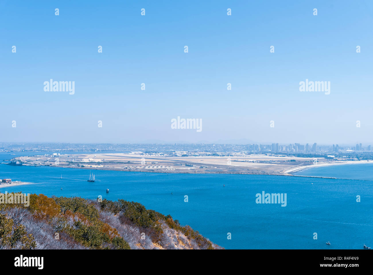 Over looking San Diego Bay from the top of Point Loma; Coronado island in background, ocean bay under a hazy blue sky. Stock Photo