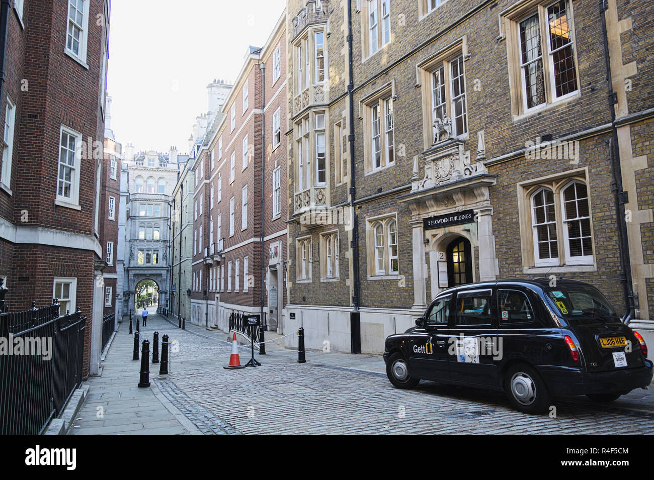 Narrow street and black taxi car in London,  City of London. Stock Photo