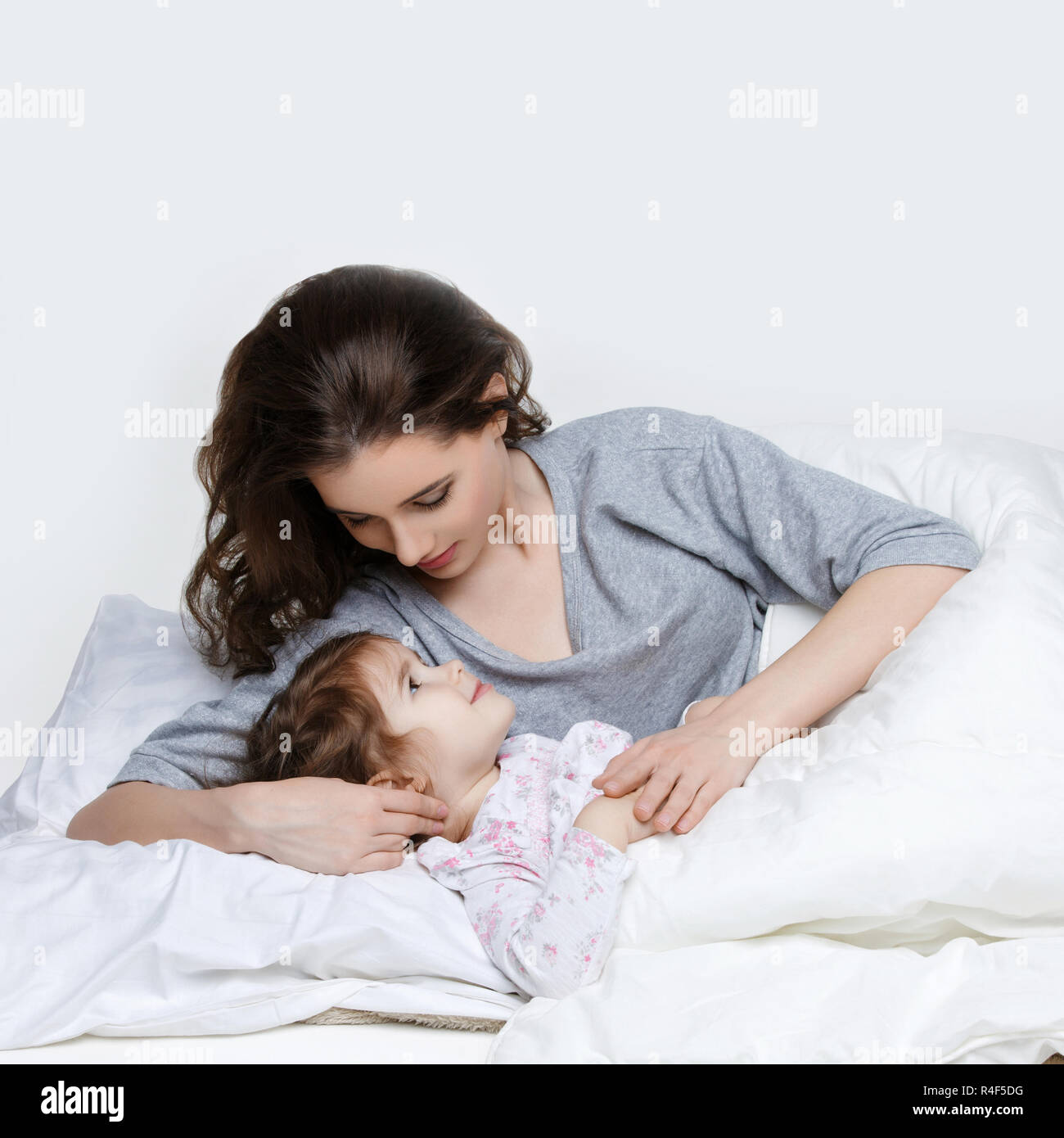 Beautiful mother and daughter in bed Stock Photo