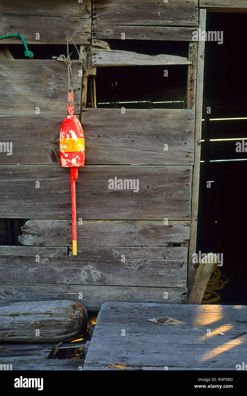 A lobster buoy hangs from an old shack in Owl's Head, Maine, USA Stock Photo