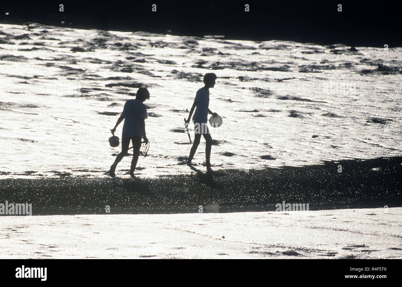 Two girls playing in the mud at low tide, Boothbay, Maine, USA Stock Photo