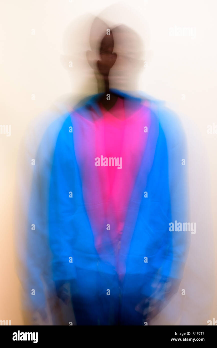 Blurred long exposure shot of young African man against white background Stock Photo