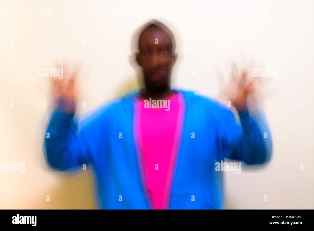 Blurred long exposure shot of young African man against white background Stock Photo
